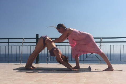 Adho mukha svanasana adjustment on yoga holiday Crete