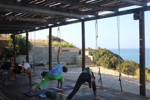 Utthita parsva konasana on yoga deck by the sea