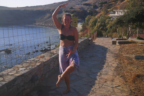Carin doing dancer pose by the sea at Yoga Rocks retreat Agios Pavlos