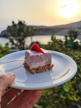Vegan raw cheese cake with strawberries and the view over the bay from Yoga Rocks